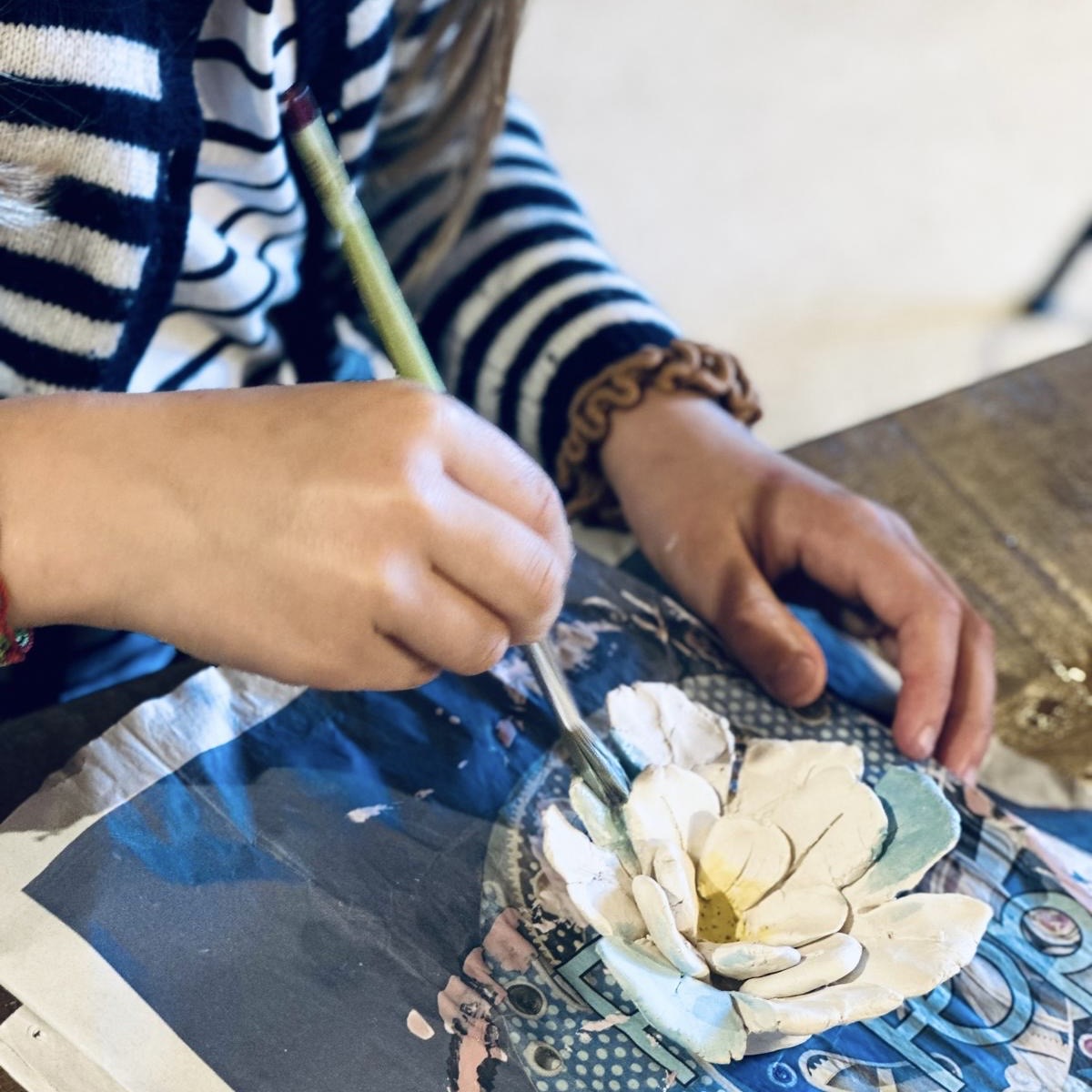 atelier épilithe : enfant déposant l'émail sur sa pièce