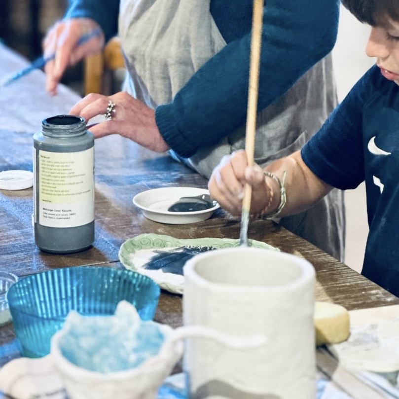 atelier épilithe : enfant déposant l'émail sur sa pièce