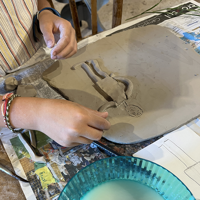 modelage par un enfant d'une plaque en bas relief